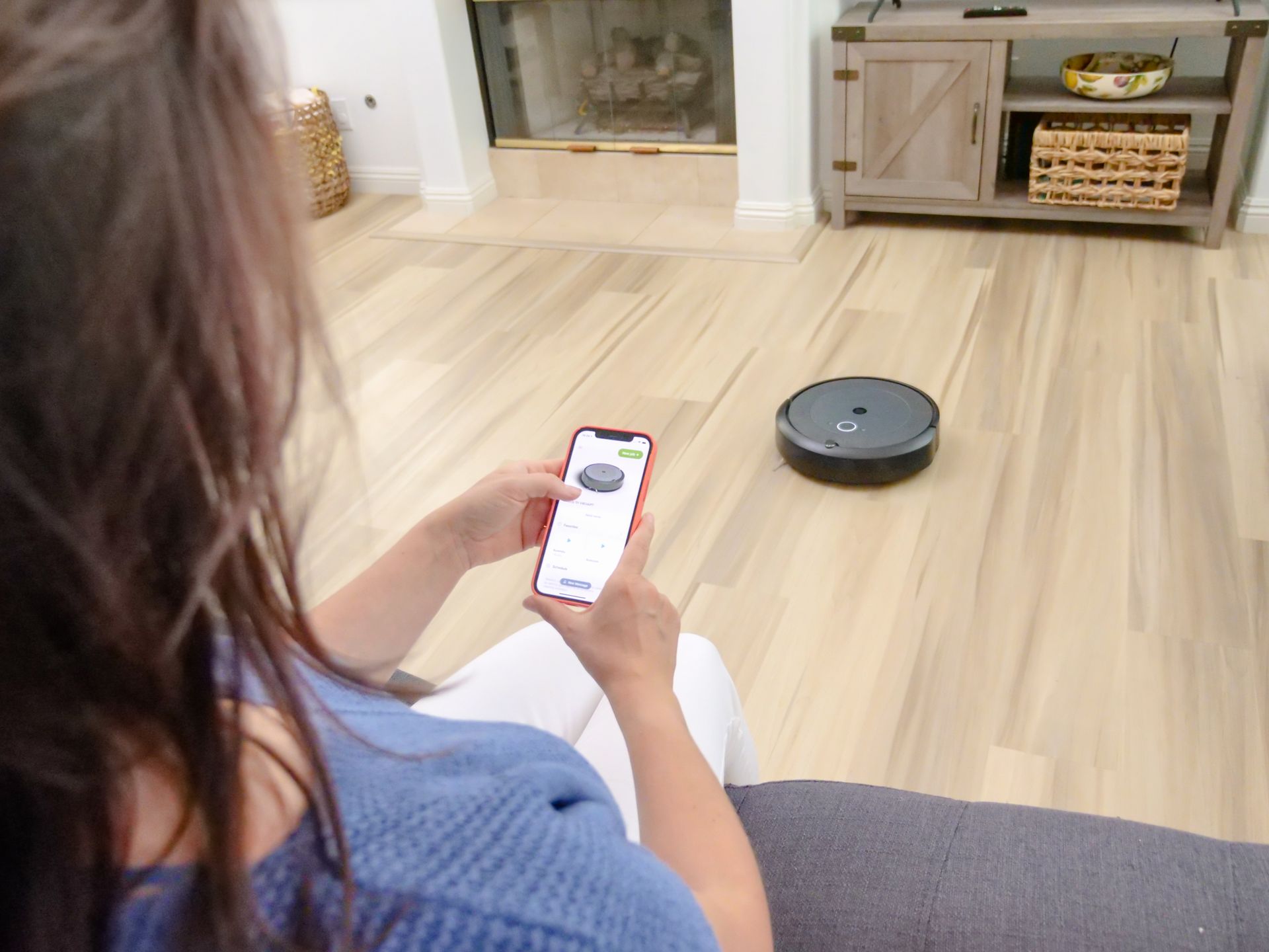 A robot vacuum docking at its base station on hardwood floor